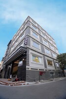 A hotel with a classic architectural design, featuring multiple floors and a prominent entrance with a canopy.