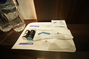 Ein Hotelzimmer mit einem Holztisch, auf dem ein Dentalset, ein Rasierkit und ein Kamm liegen.