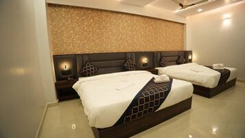 A hotel room with two beds, a decorative wall, and a ceiling fan.