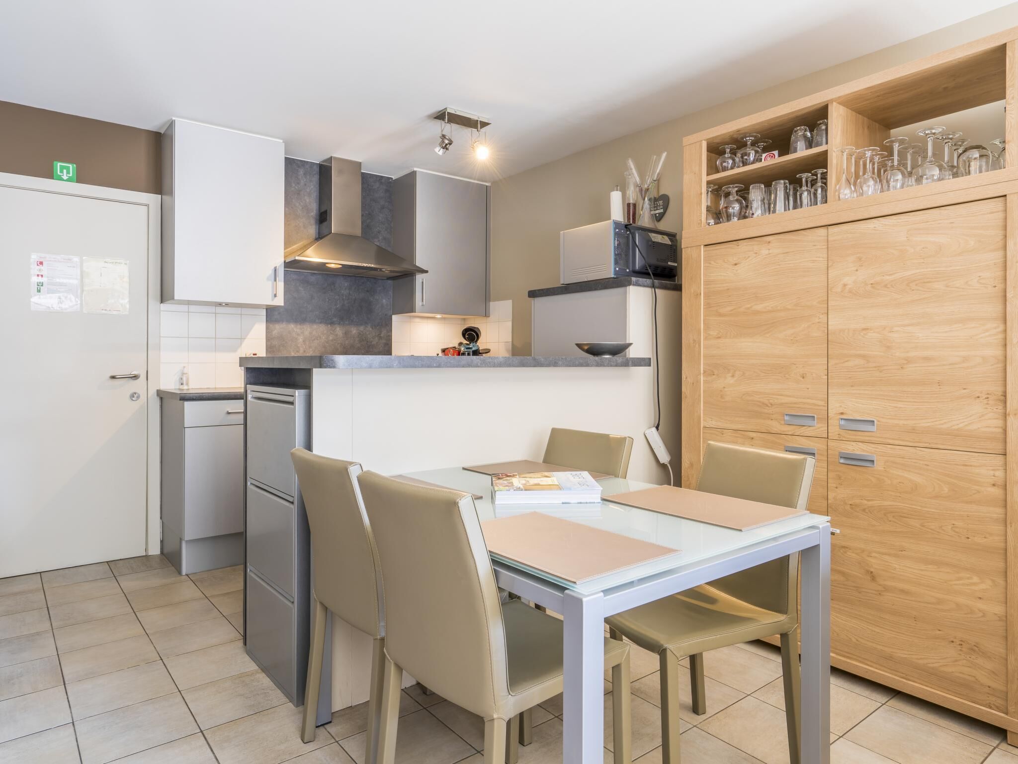 A compact kitchen with a dining area, equipped with a refrigerator, stove, and cabinets.