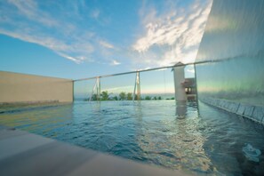 Una piscina amb vista al cel i palmeres allunyades.