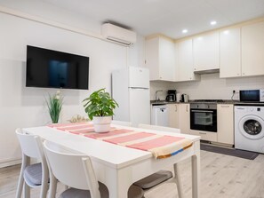 A modern kitchen with white cabinets, a built-in oven, microwave, and washing machine. - Apartment with excellent beachfront location (Santa Susanna)