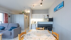 Een gezellig compacte ruimte met een eettafel, een bank, een keukenhoekje en een kleinere eettafel.