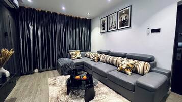 Departamento Deluxe, balcón, vista a la ciudad | Área de sala de estar