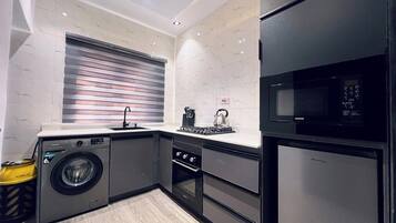 Departamento Deluxe, balcón, vista a la ciudad | Cocina privada | Refrigerador, microondas, horno y parrilla de estufa