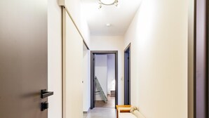 Un pasillo estrecho con un banco de madera y una puerta a la izquierda.