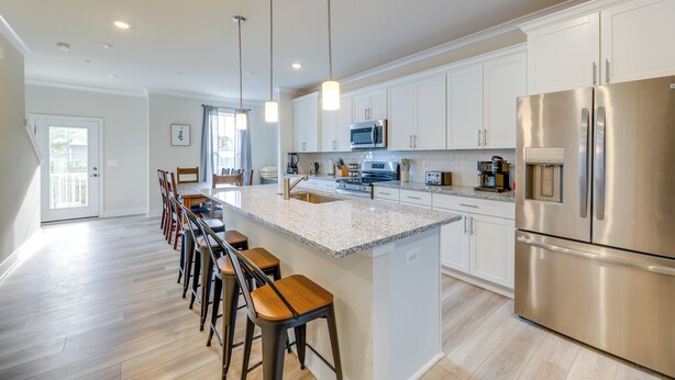 A modern kitchen with a central island, stainless steel appliances, and pendant lighting. - Pool Access! Newly Built Ocean City Townhome (Ocean City)