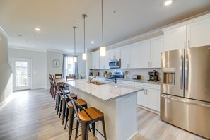 A modern kitchen with a central island, stainless steel appliances, and pendant lighting. - Pool Access! Newly Built Ocean City Townhome (Ocean City)