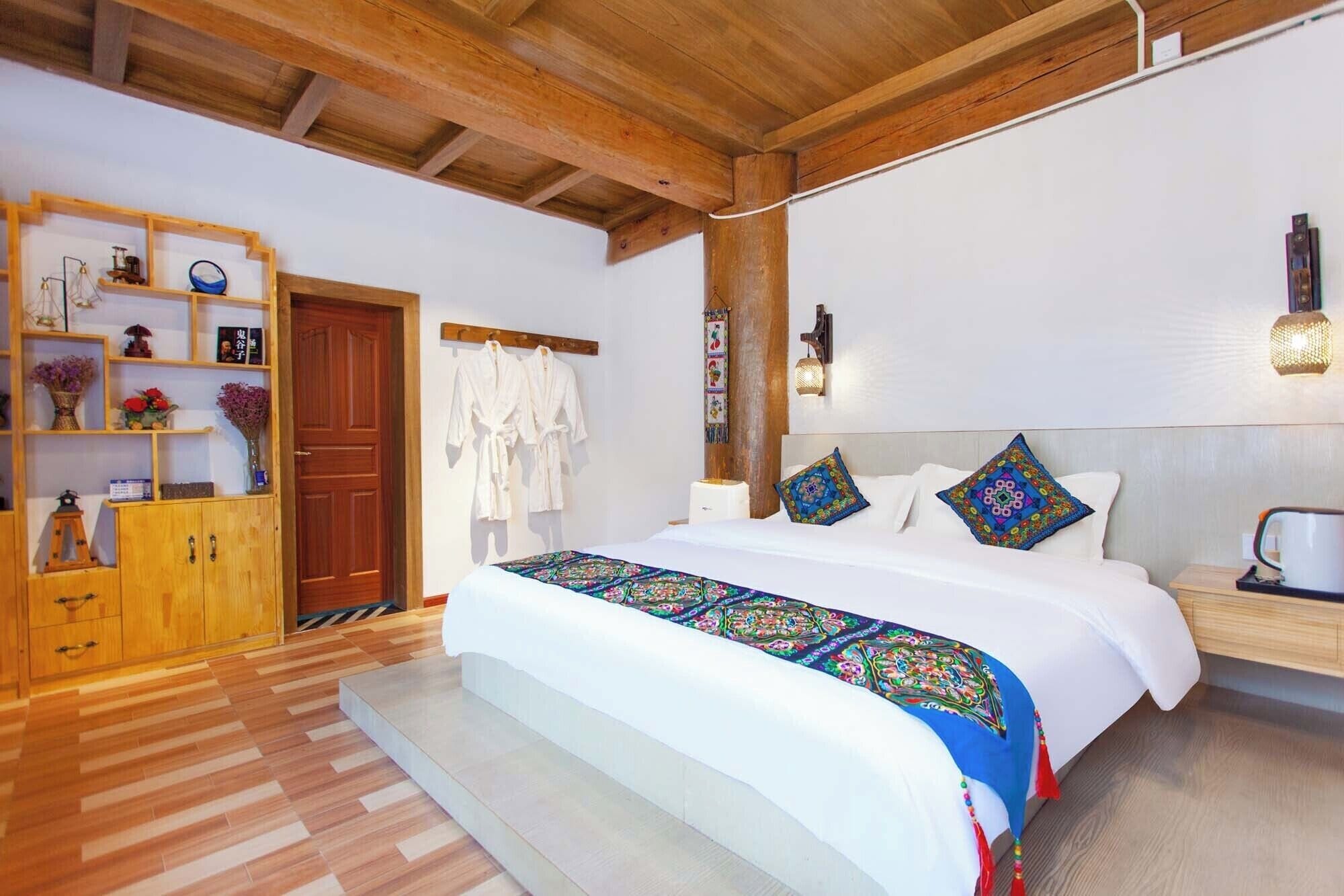 Un dormitorio amplio con una cama grande, cabecero de madera y un armario empotrado.