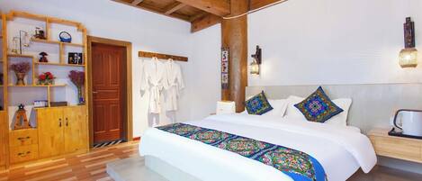 Un dormitorio amplio con una cama grande, cabecero de madera y un armario empotrado.