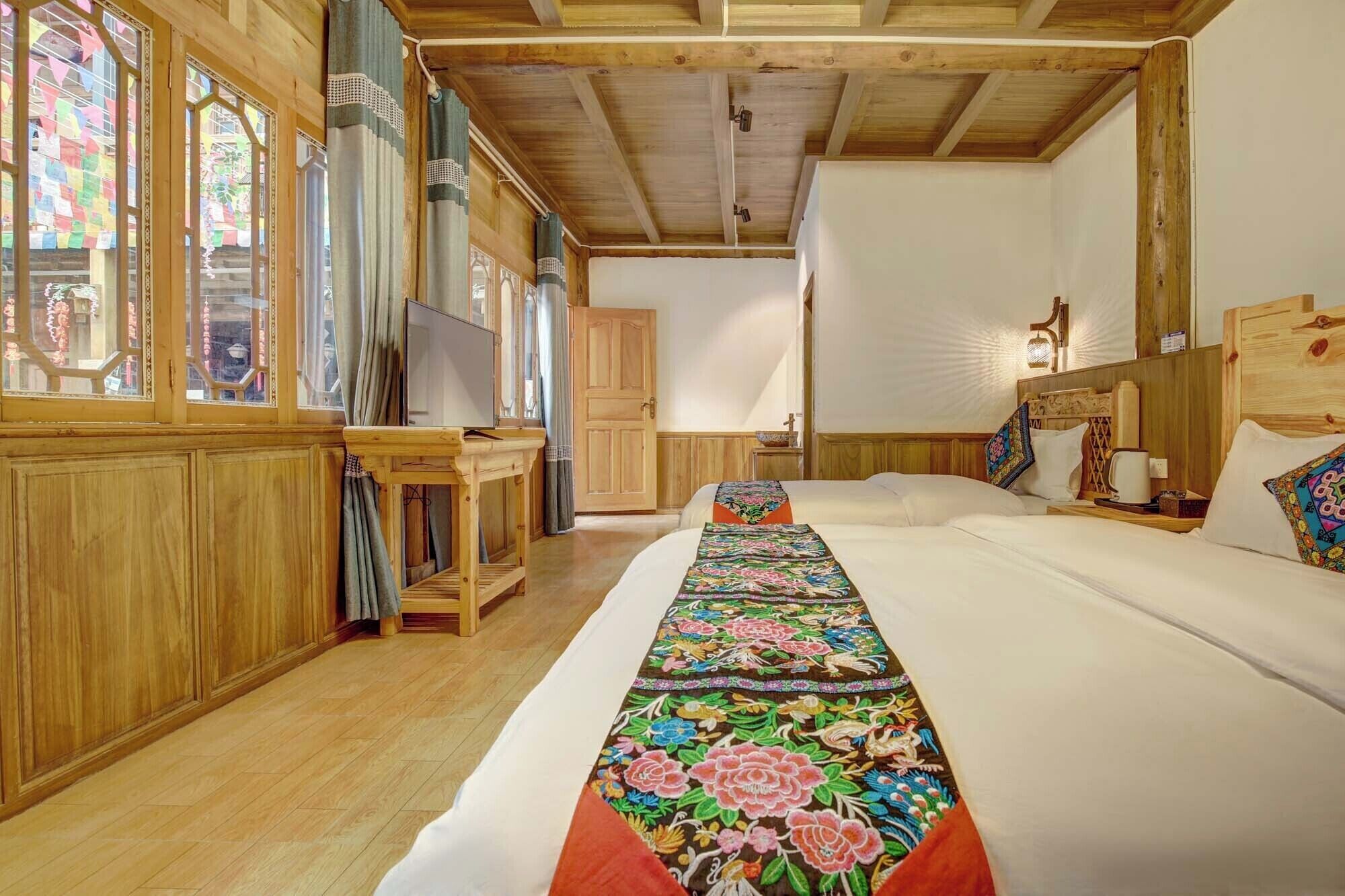 A room with a large bed, wooden walls, and a window with colorful notes.