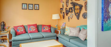 A living room with two sofas, a coffee table, and a ceiling fan.