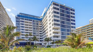 A multi-story hotel with balconies, palm trees, and a clear blue sky. - Steps to Sand! 10th-Floor Ocean Manor Unit w/ Pool (Fort Lauderdale)