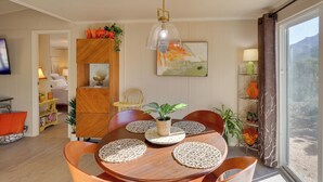 A dining area with a wooden table, chairs, and a hanging light fixture. - Hualapai Mtn Views on 2 Acres: 'Thunderhead' Home (Kingman)