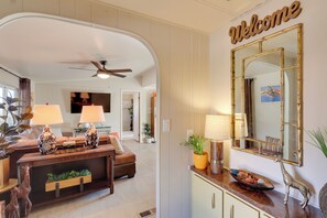 A living room with a sofa, two lamps, a console table, and a decorative mirror.