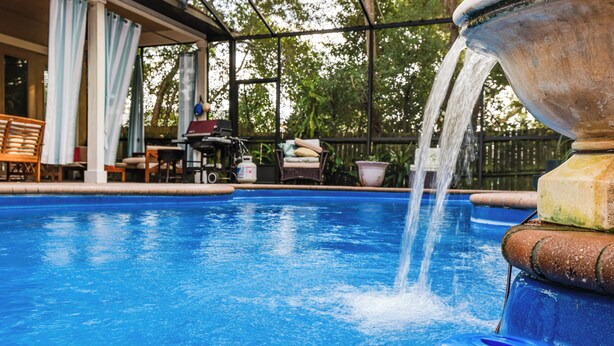 A swimming pool with a water fountain, outdoor furniture, and a covered patio area. - Canal-Front Retreat w/ Hot Tub & Dock in Tavares (Tavares)