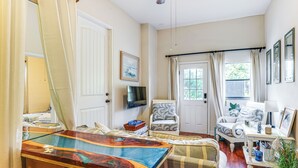 A living room with a wooden coffee table, a sofa, a chair, and a television on the wall. - Canal-Front Retreat w/ Hot Tub & Dock in Tavares (Tavares)