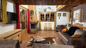 A cozy living room with a fireplace, wooden furniture, and a cowhide rug. - Infinitely mountainous atmosphere, ski in/ski out chalet in Arêches Beaufort (Beaufort)