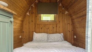 A wooden-paneled bedroom with a bed, a window, and a ceiling fan. - Birds pod is the perfect place for up to two guests to reconnect with nature. (Dalton-in-Furness)