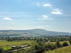 A rural landscape with rolling hills, a road, and scattered buildings. - Wensleydale Retreat - UK50456 (Leyburn)