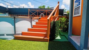 A set of orange outdoor stairs leading to a covered area with a sign that reads "Bestway St." - Anrym Apartments MUP - by Zenbreak (St. Lawrence Gap)