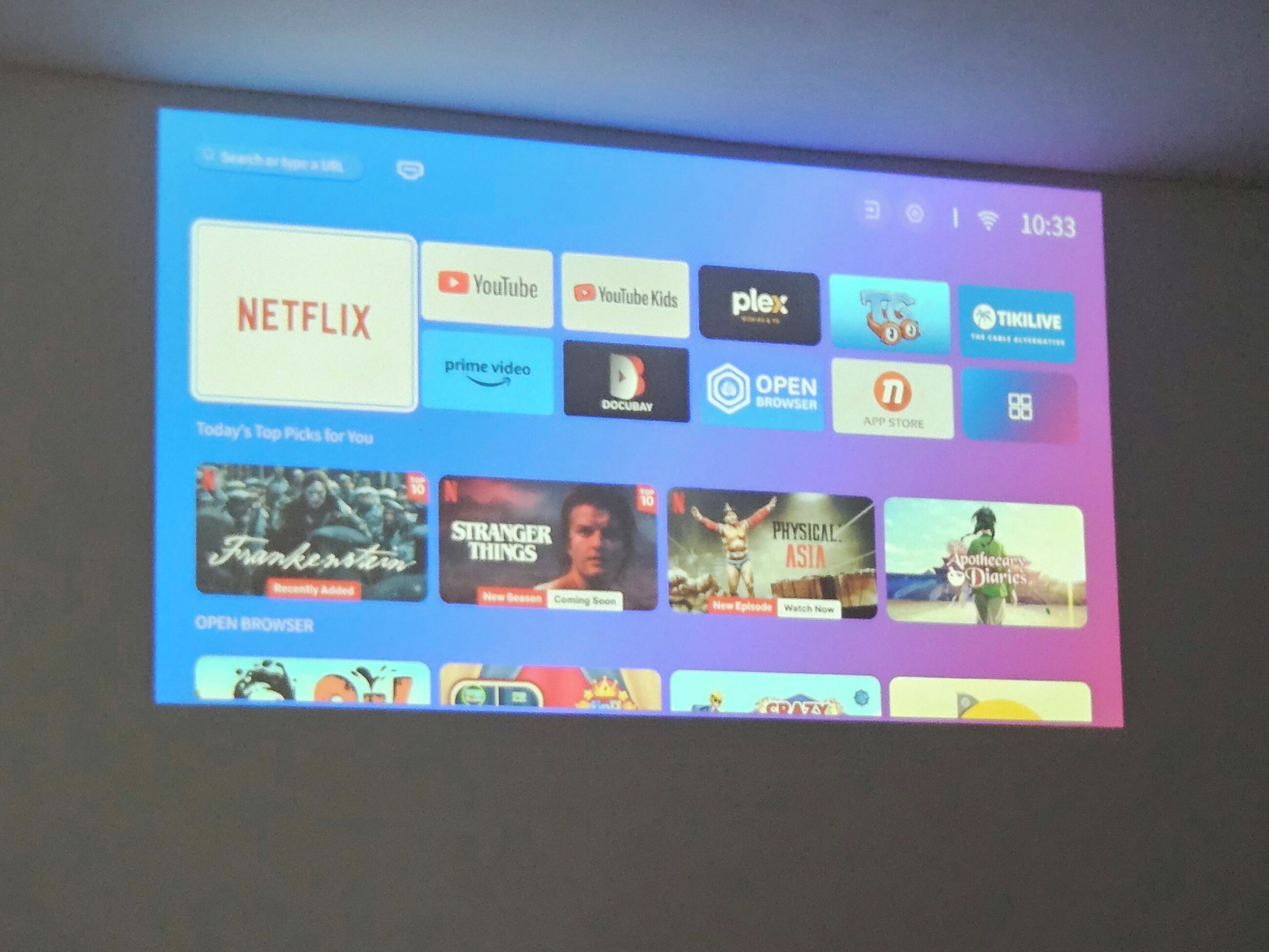 A projection of a streaming service interface with various platform logos and TV show thumbnails.