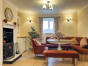 A cozy living room with a fireplace, a round table, and comfortable seating. - 3 bedroom accommodation in Areley Kings, Near Stourport on Severn (Areley Kings, Near Stourport on Severn)
