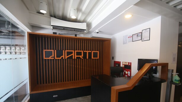 A reception desk with a modern design, featuring a wooden panel wall with the word "LOFT" prominently displayed. - Quarto PH (Makati)