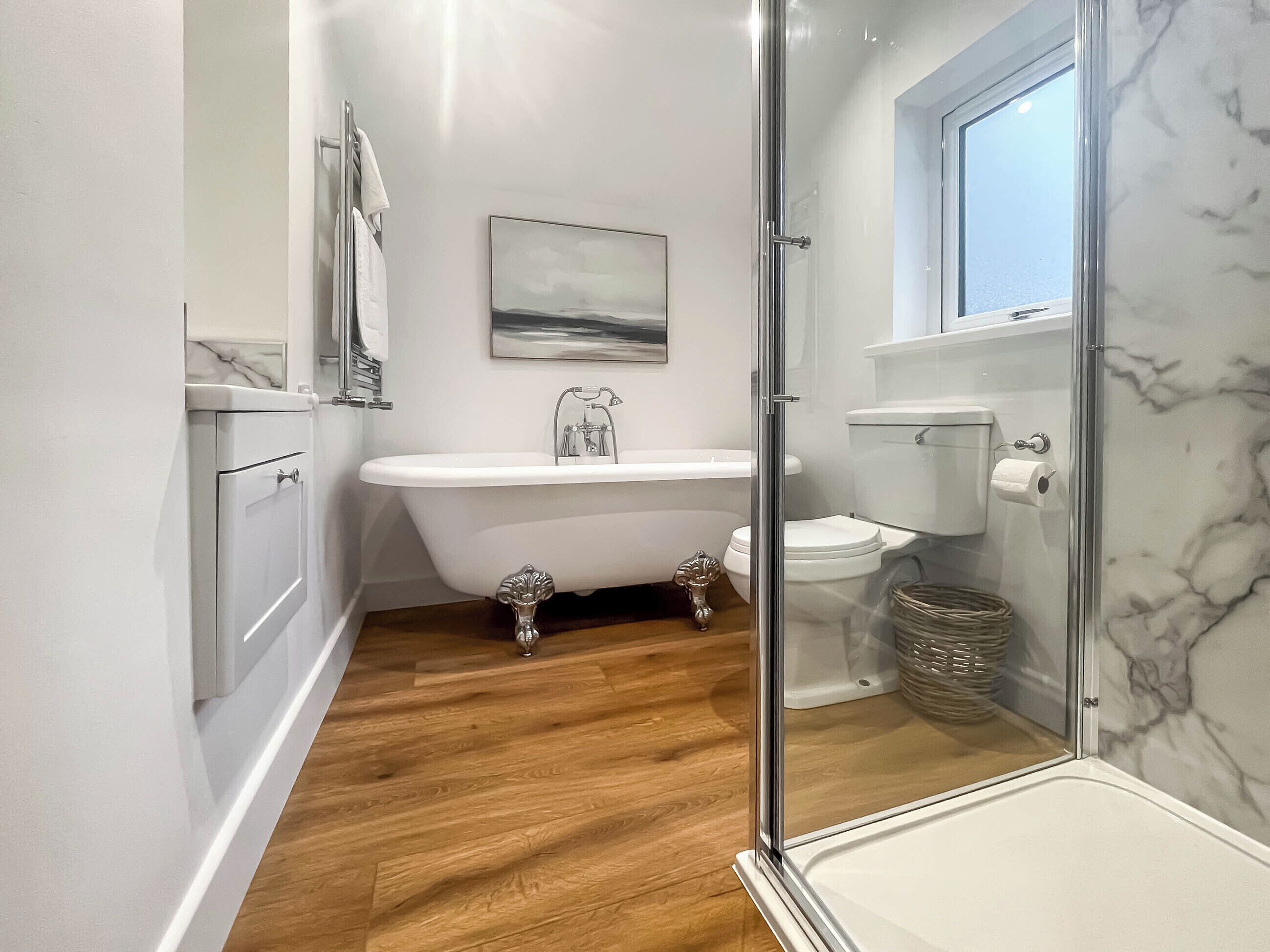 A modern bathroom with a freestanding bathtub, a toilet, and a shower enclosure.