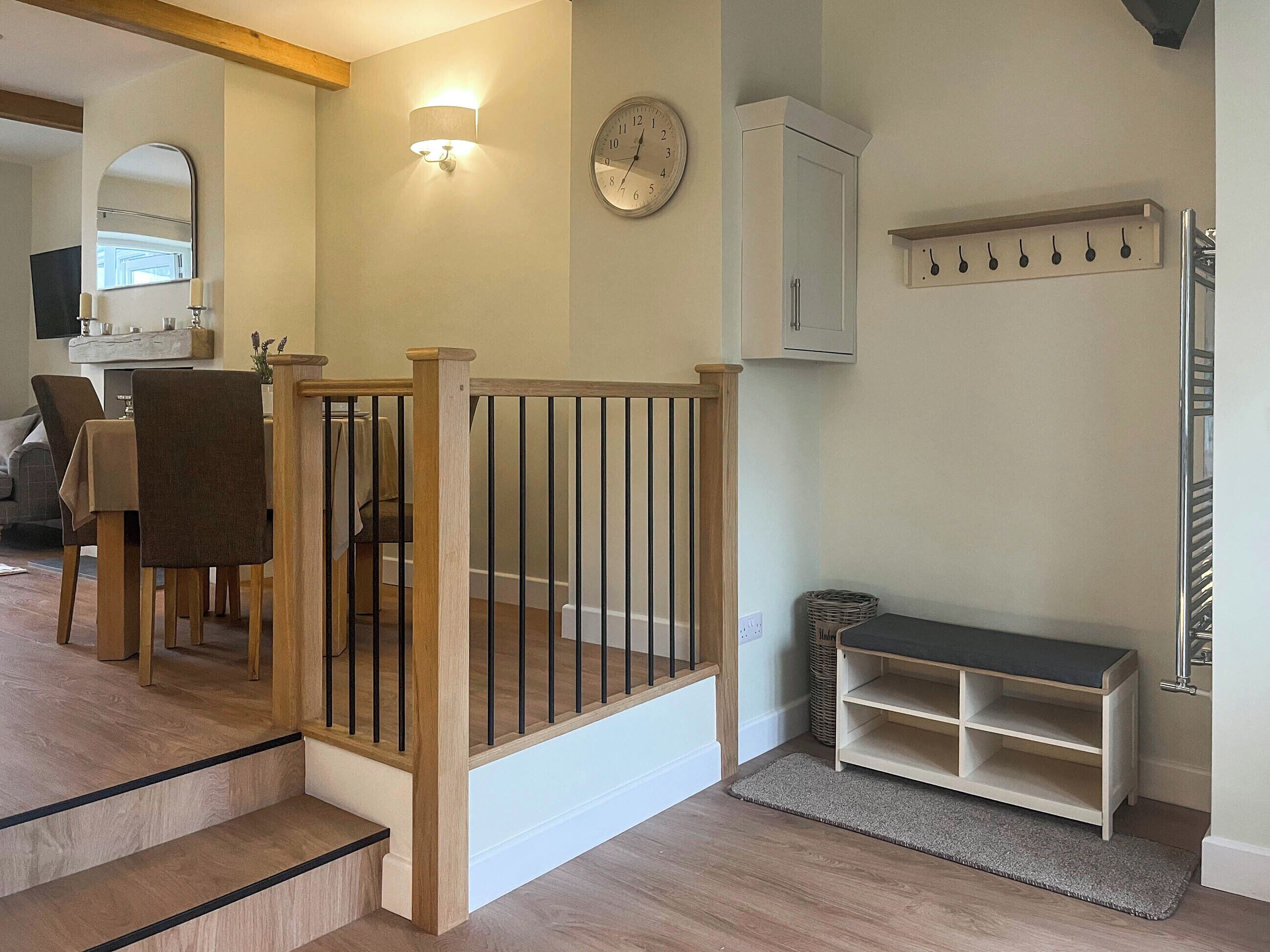A staircase with wooden railings leading to a dining area with chairs and a table.