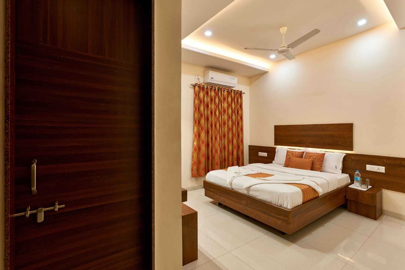 A bedroom with a wooden bed, a ceiling fan, and an air conditioning unit.