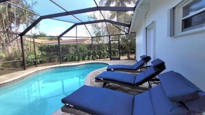 Ein Pool mit Glasumrandung, umgeben von Liegestühlen.