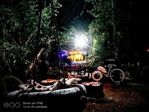 A rustic outdoor seating area with a bicycle and a sign that reads "CAGE KOTTU". - Anura Homestay (Sigiriya)