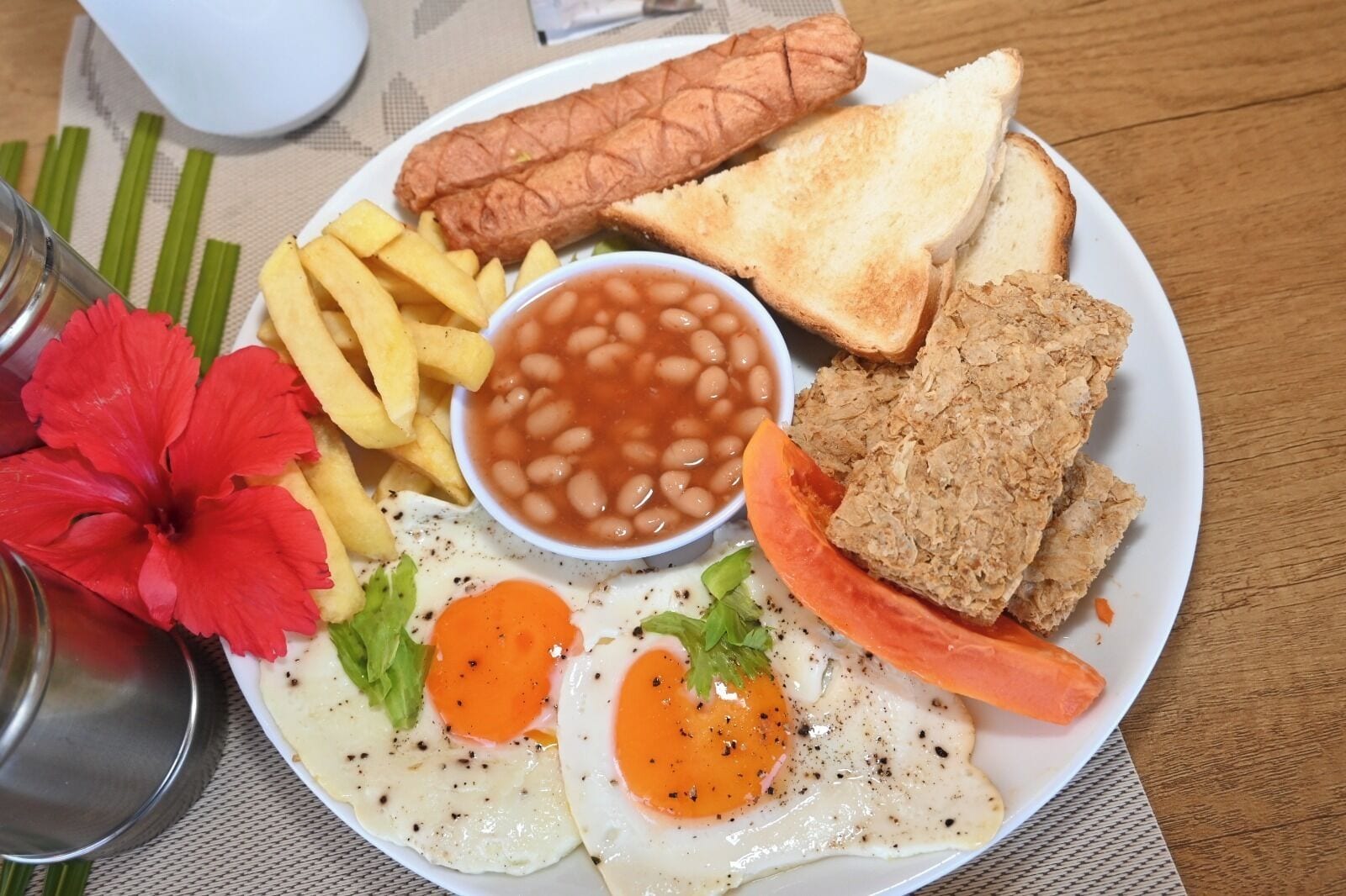 En tallrik med ägg, bönor, korv, rostat bröd och pommes frites.
