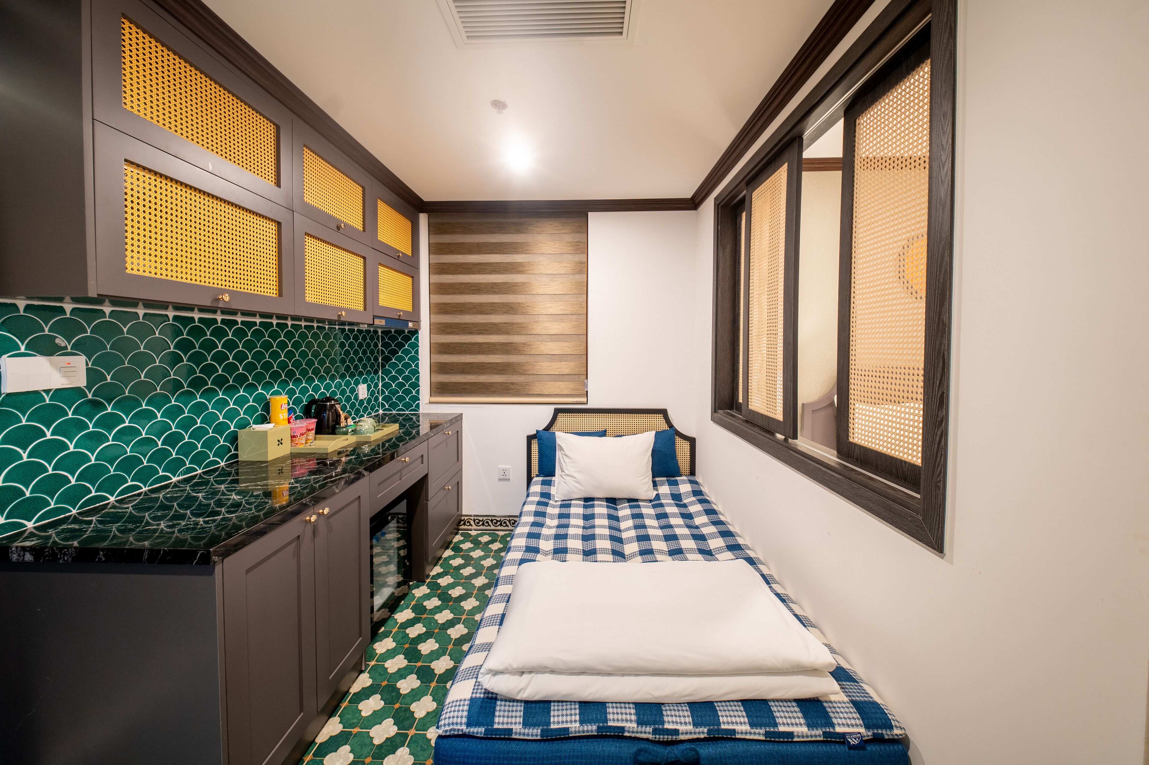 Una habitación compacta con cama, una kitchenette pequeña y ventana con vistas.