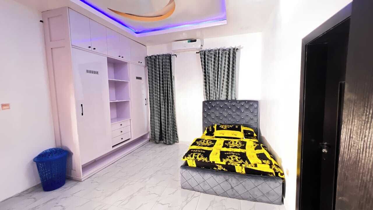 Un dormitorio con cama, armario y cortinas.