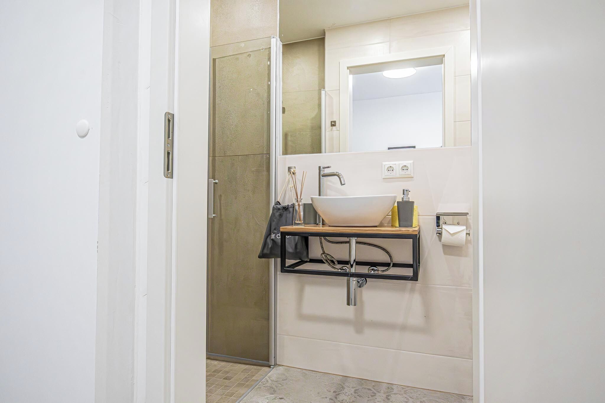 A bathroom with a white sink, a mirror, and a towel rack.