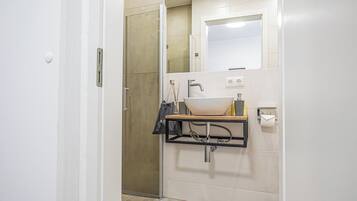A bathroom with a white sink, a mirror, and a towel rack.