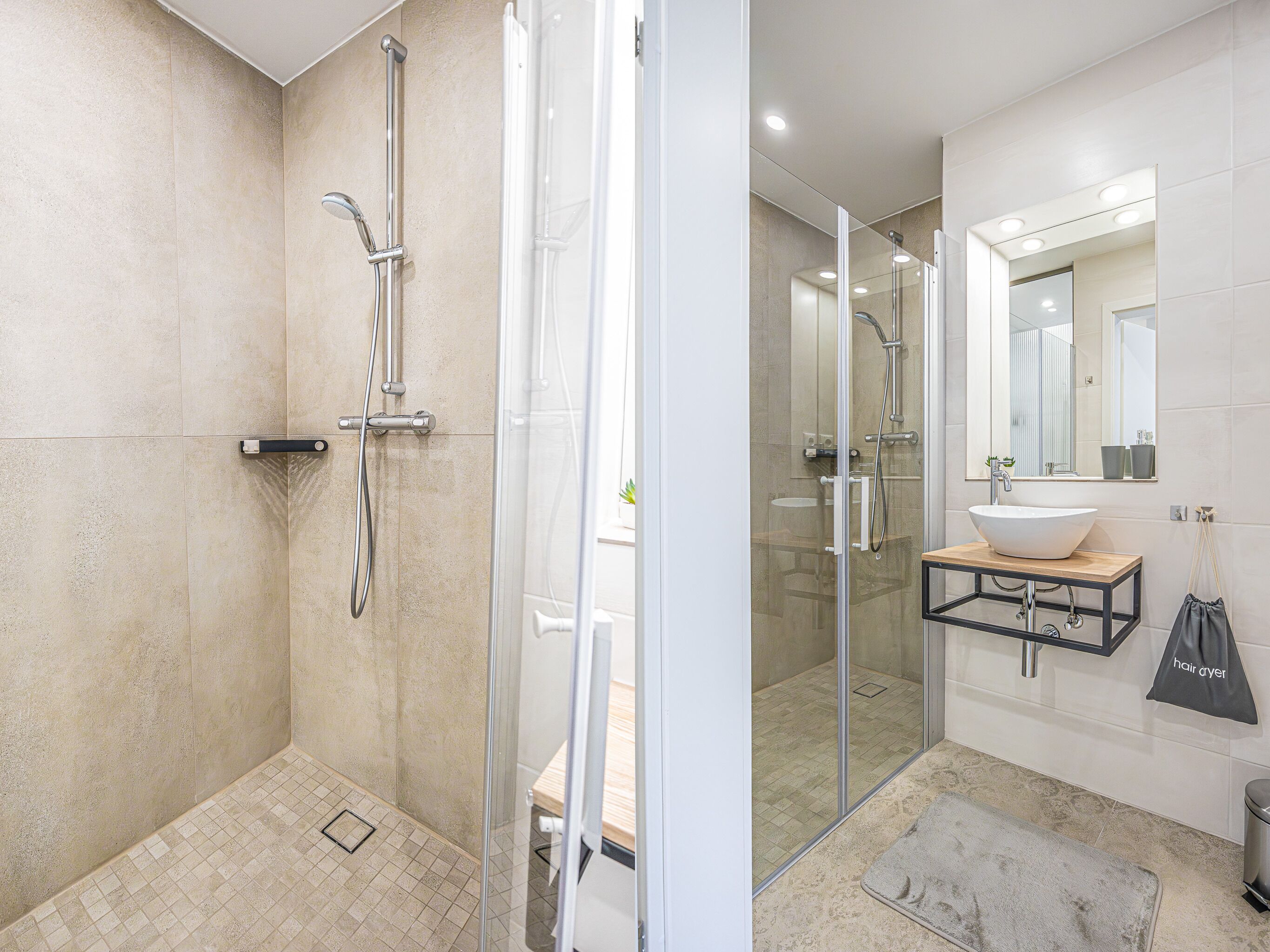 A modern bathroom with a glass-enclosed shower, a sink with a mirror, and a bench.