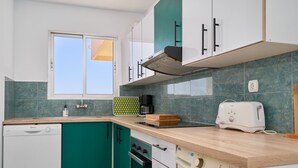 Une cuisine moderne équipée d’un lave-vaisselle, d’un four et d’un lave-linge.