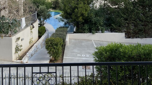 Quartiere residenziale con piscina, circondato da alberi e palazzi.