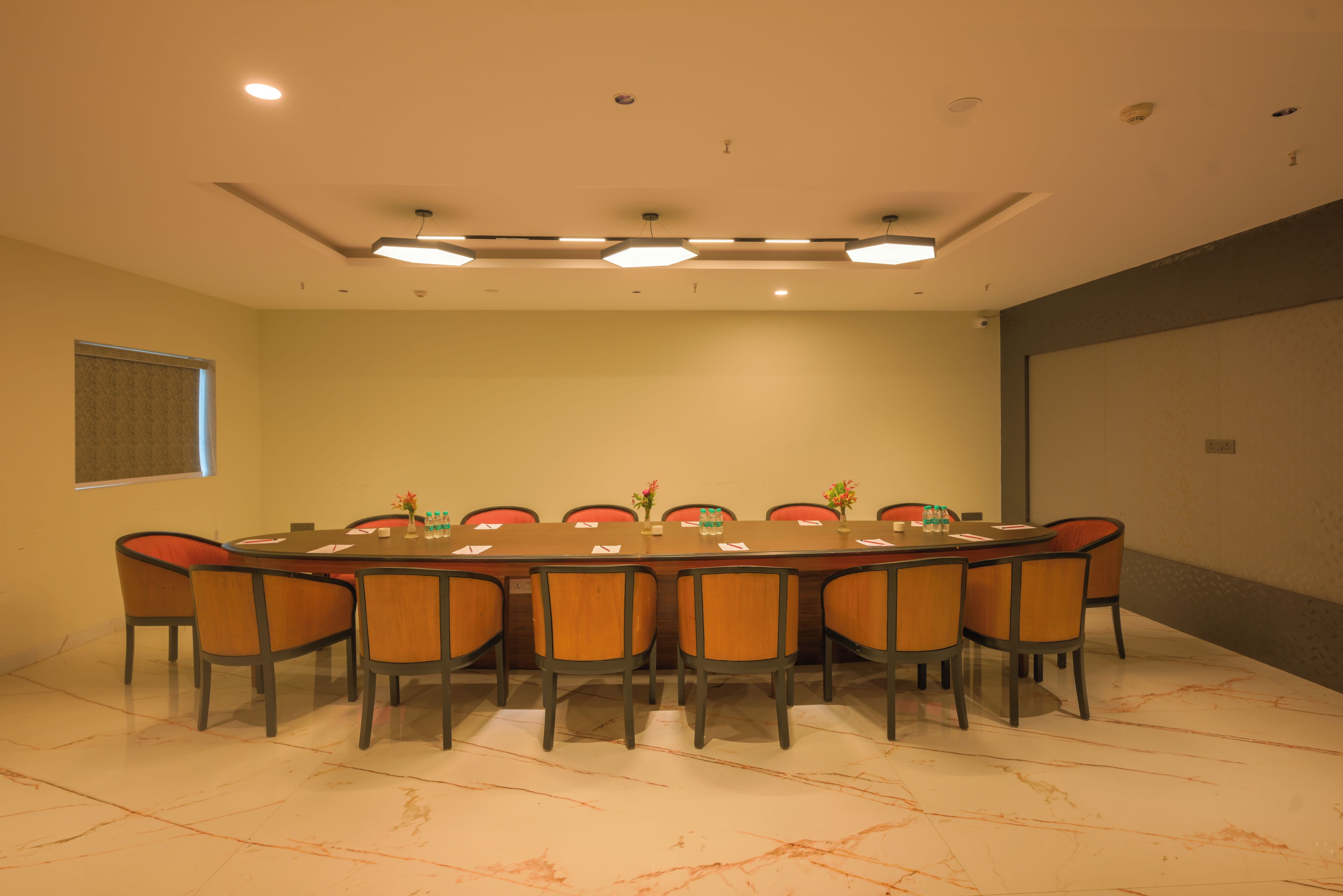 A conference room with a long table, chairs, and a window.