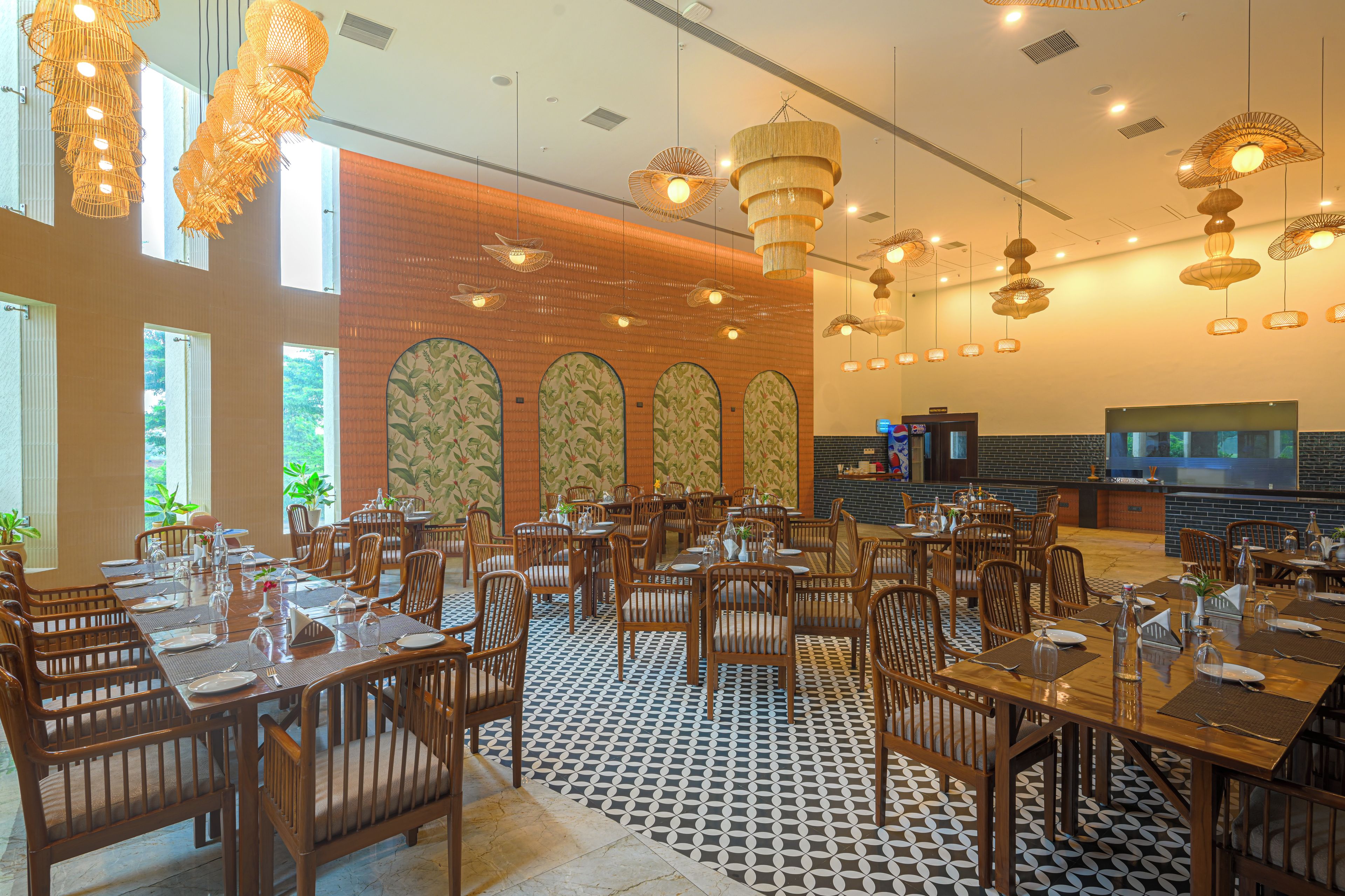 A restaurant with multiple dining tables, chairs, and hanging light fixtures.