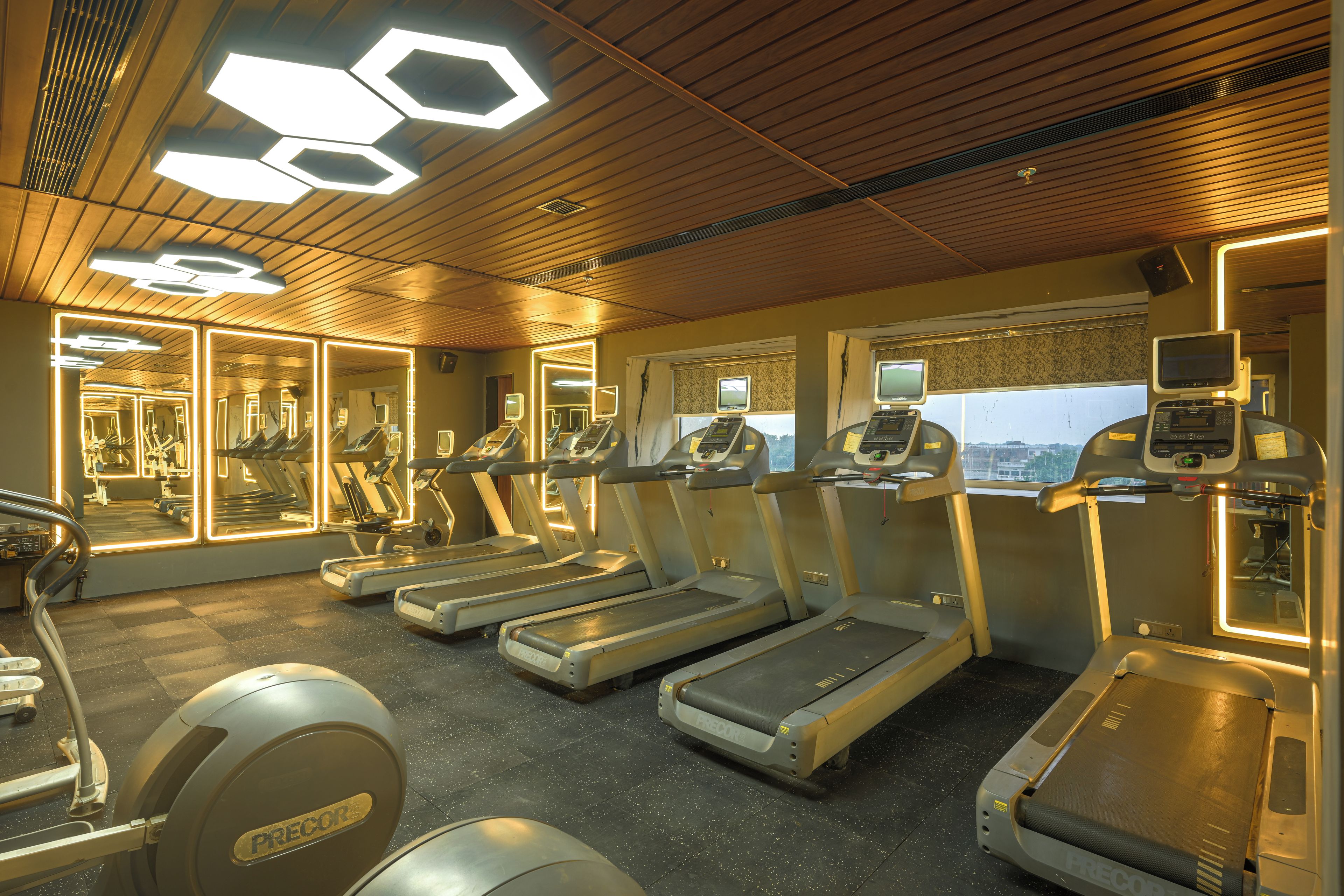 A gym with treadmills, exercise bikes, and mirrors.