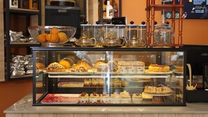 Una vitrina de panadería con diversos pasteles y postres.