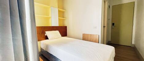 Un dormitorio con cama, cabecera de madera y estanterías empotradas.