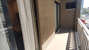 A balcony with a view of the street, a sliding glass door, and a small window. - Taishan guest house (Addis Ababa)