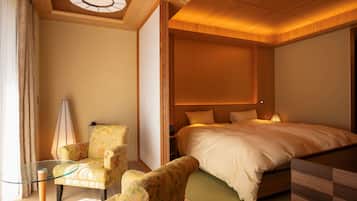 A hotel room with a bed, a chair, a table, and a ceiling light fixture.