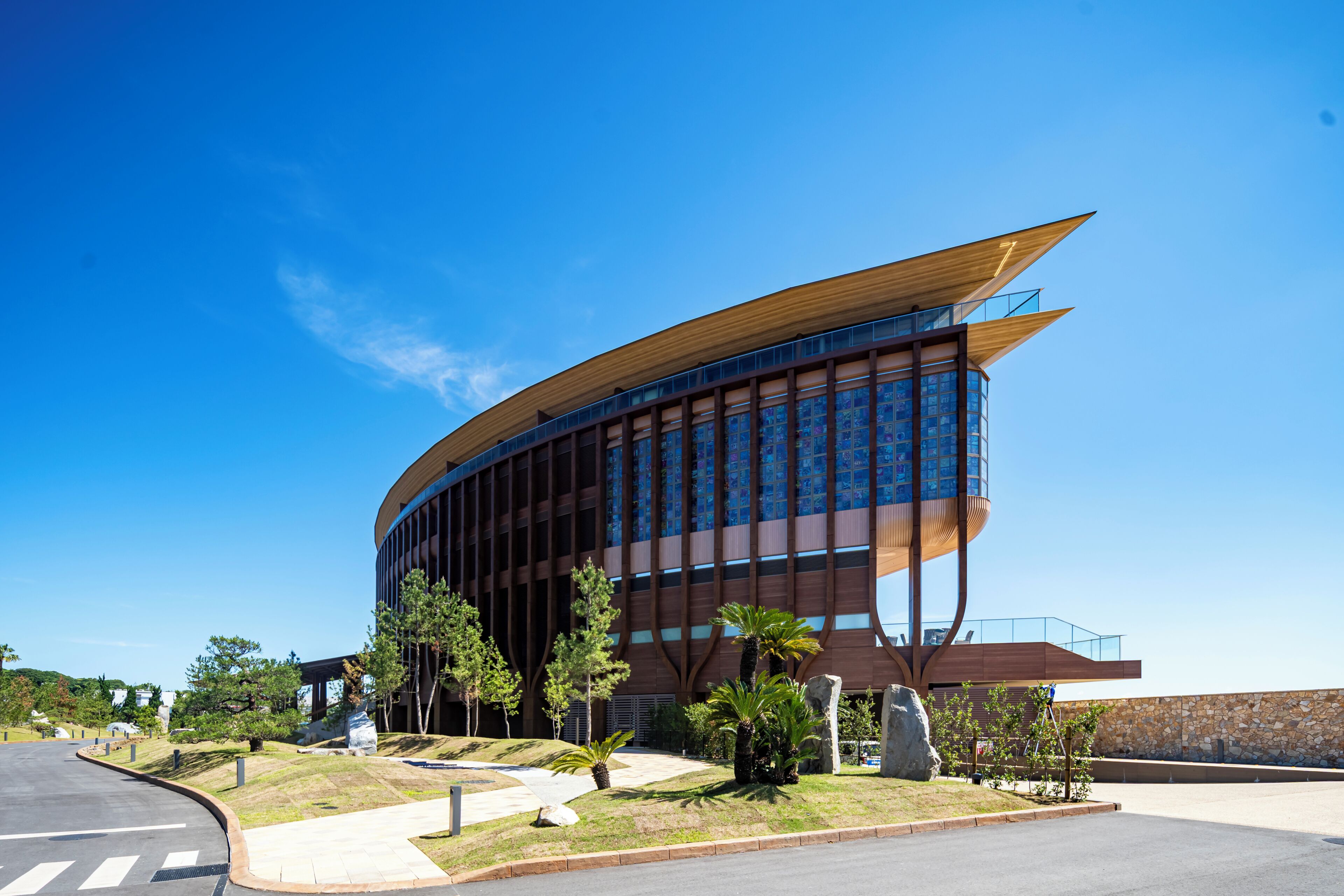 A modern building with a curved facade, large windows, and a prominent entrance.