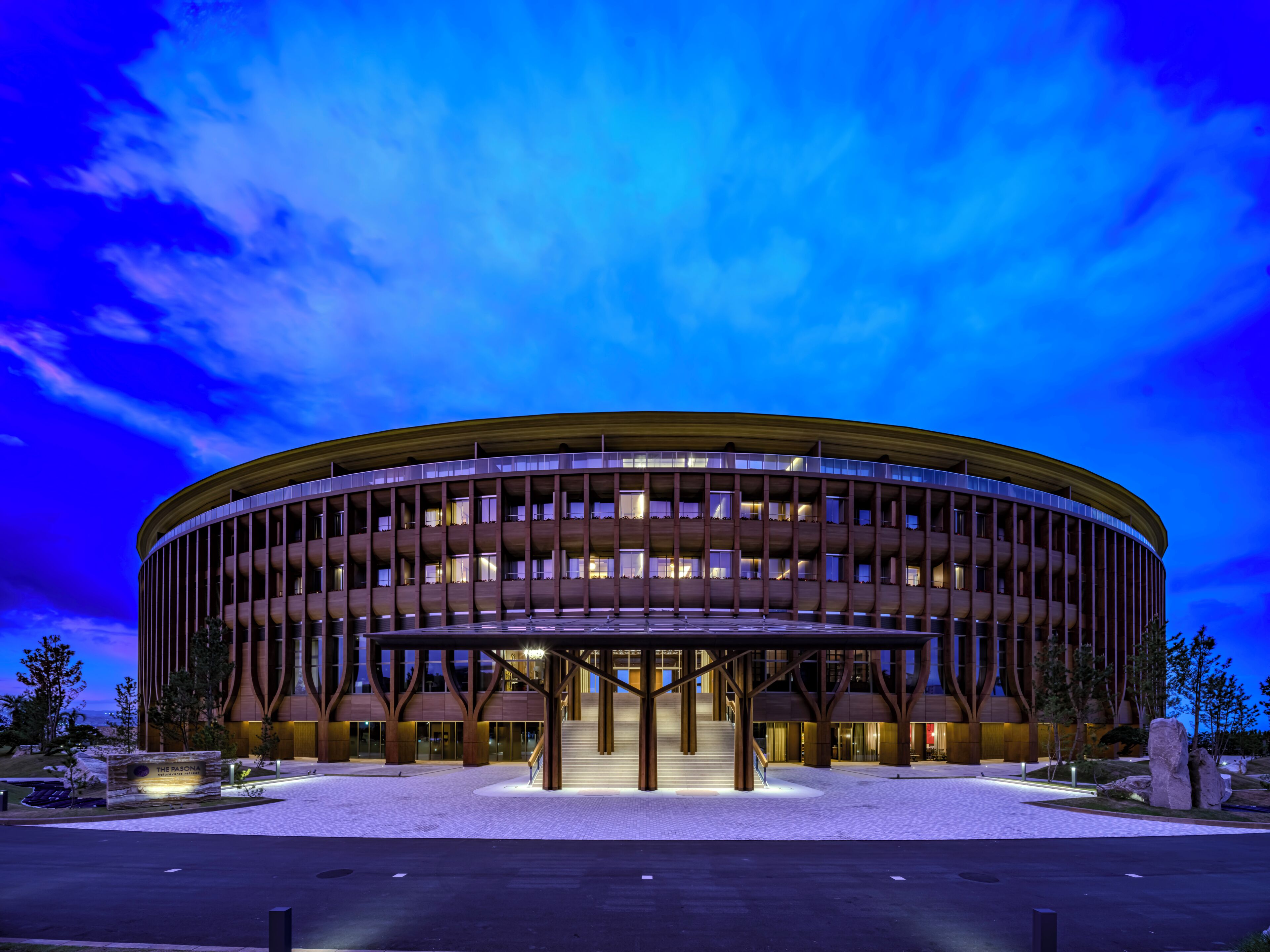 A modern building with a circular design, featuring a central open area and multiple floors.
